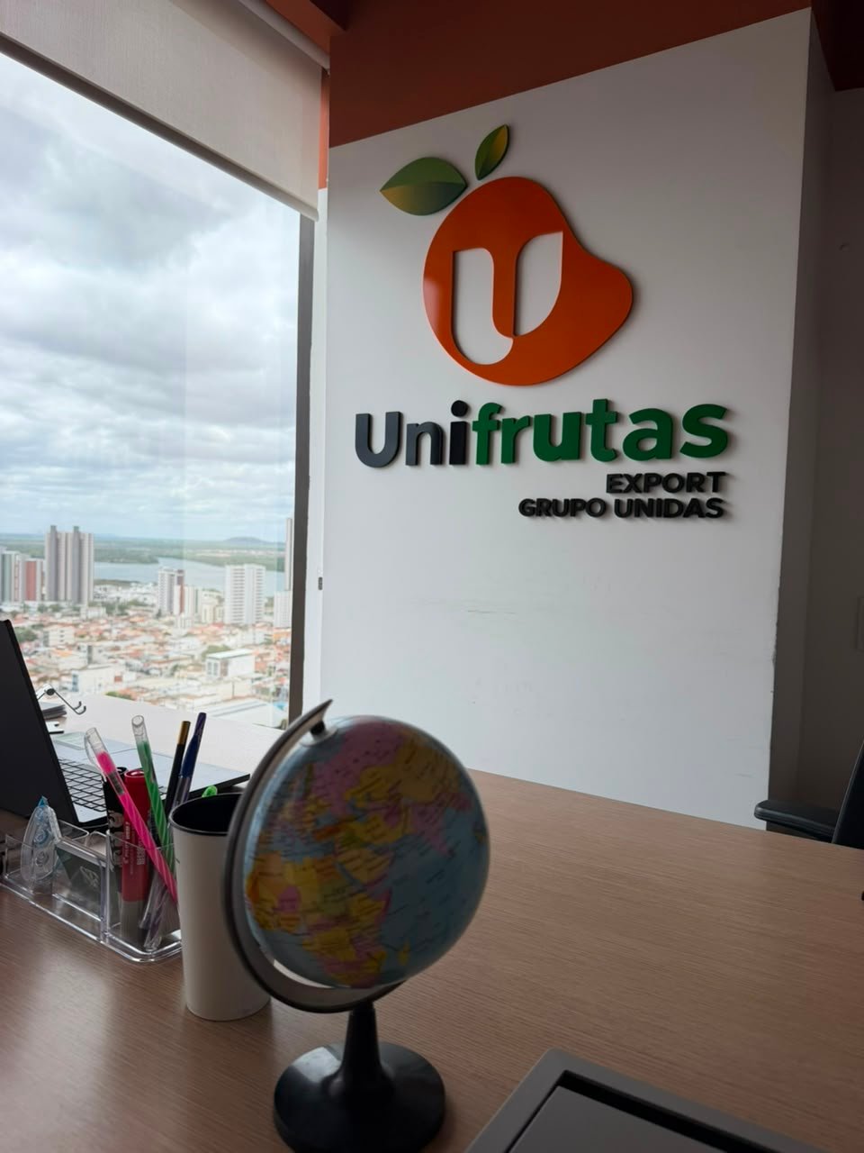 Escritório da Unifrutas em Petrolina, com a logo na parede e vista para a cidade